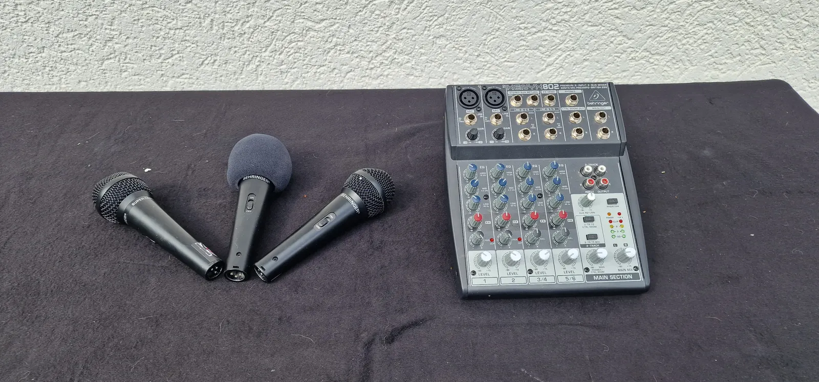 Drei Gesangsmikrofone neben einem Kleinmischpult Behringer XENYX 802